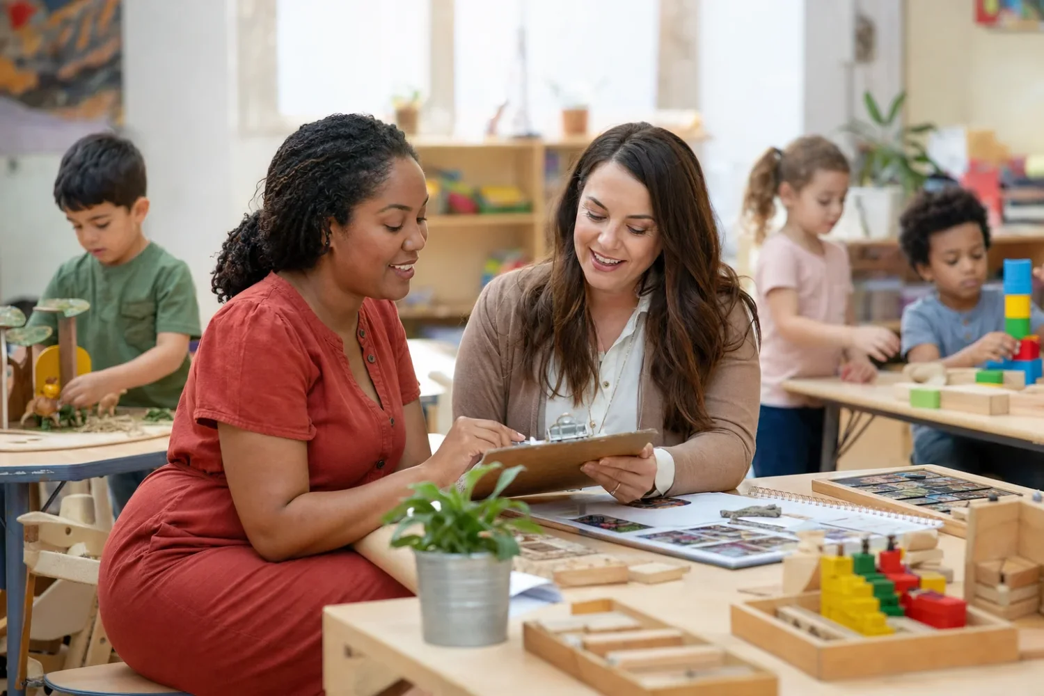Describe two adults talking in a classroom while children play, without identifying them as named consultants.